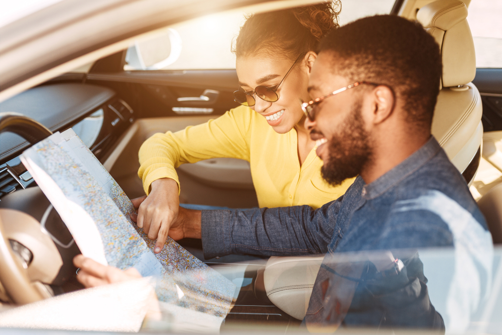 Travel,Concept.,Afro,Couple,Driving,In,Car,And,Searching,Location